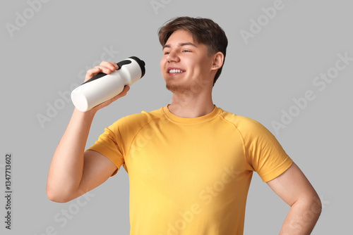 Sporty young man drinking w...