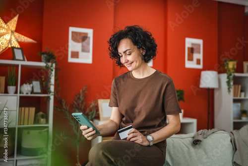 curly hair woman buy online on cellphone with credit card at home