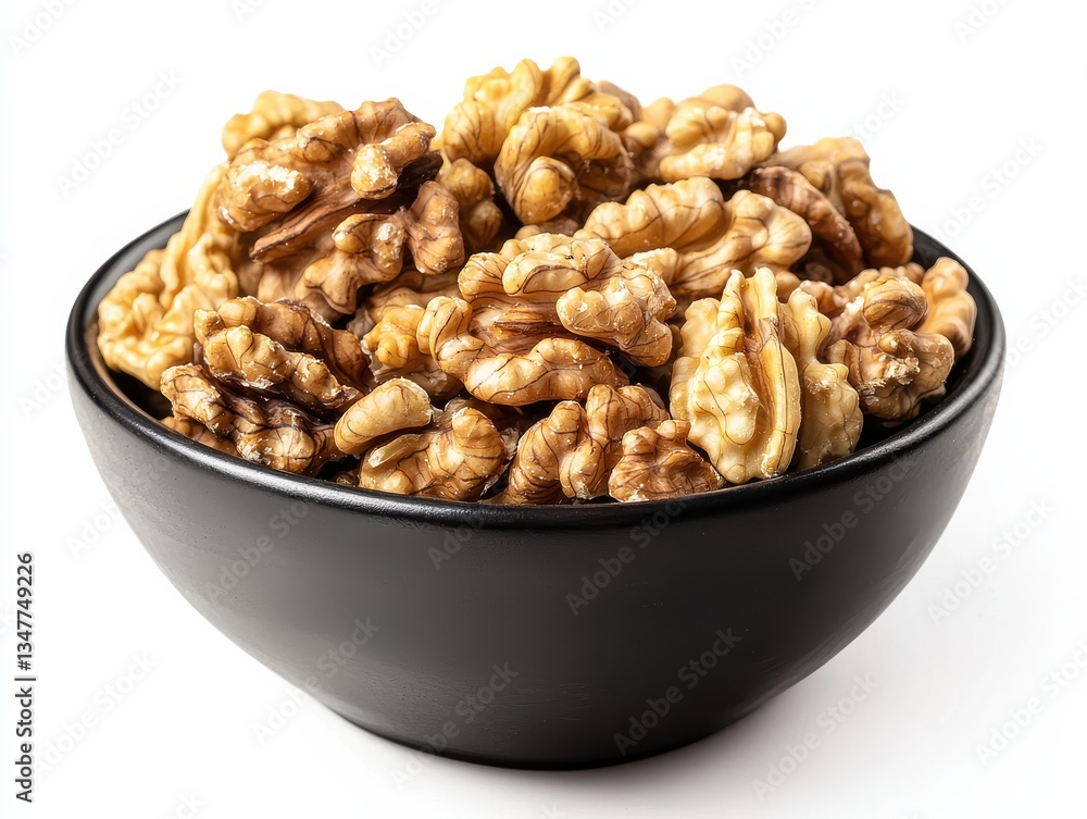 Walnut halves in a black ceramic bowl on white background Walnut halves in a black ceramic bowl on white background