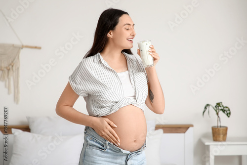 Young pregnant woman drinki...