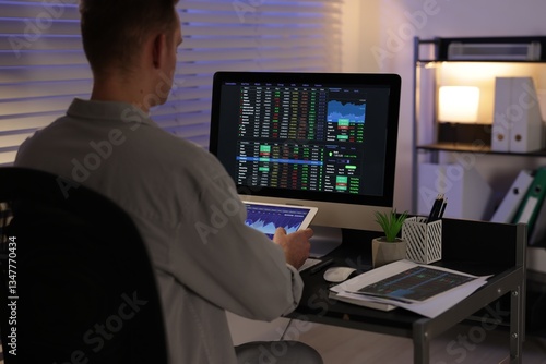 Wallpaper Mural Stock exchange. Man working in office at night, back view Torontodigital.ca