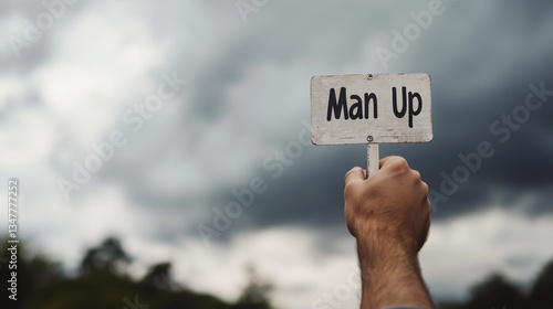 A hand crushing a Man Up sign represents toxic masculinity