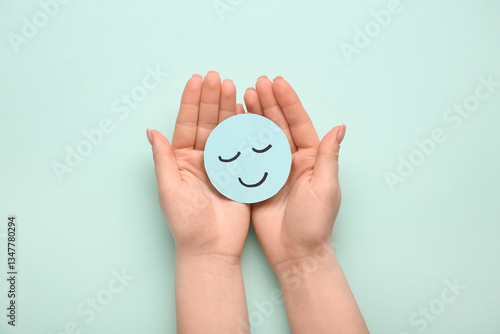 Female hands with paper smile on green background. World Health Day