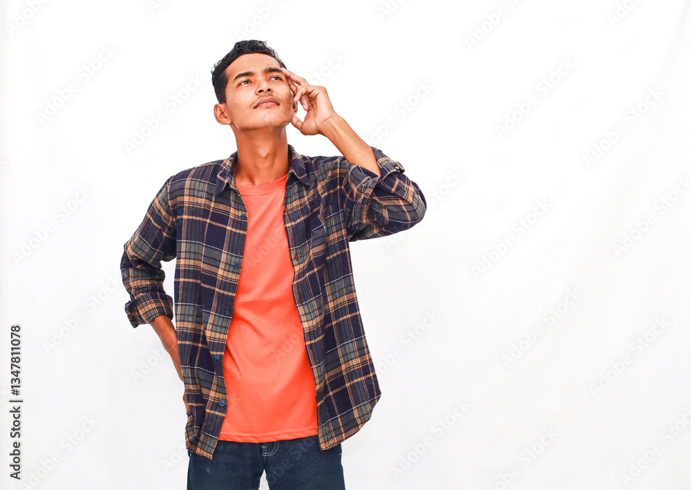 A young man contemplating a creative idea, while wearing a fashionable flannel shirt A young man contemplating a creative idea, while wearing a fashionable flannel shirt