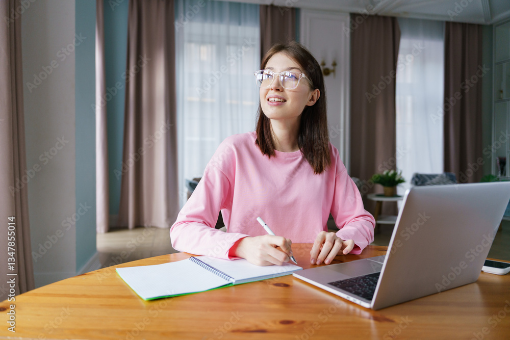 Young girl studies diligently at home using a laptop during afternoon sunlight in her cozy living space Young girl studies diligently at home using a laptop during afternoon sunlight in her cozy living space