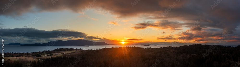 Aerial view of a dramatic sunset behind Orcas Island in the San Juan Islands archipelago. Looking across Rosario Strait this colorful sunset is seen from Lummi Island, Washington state. Aerial view of a dramatic sunset behind Orcas Island in the San Juan Islands archipelago. Looking across Rosario Strait this colorful sunset is seen from Lummi Island, Washington state.