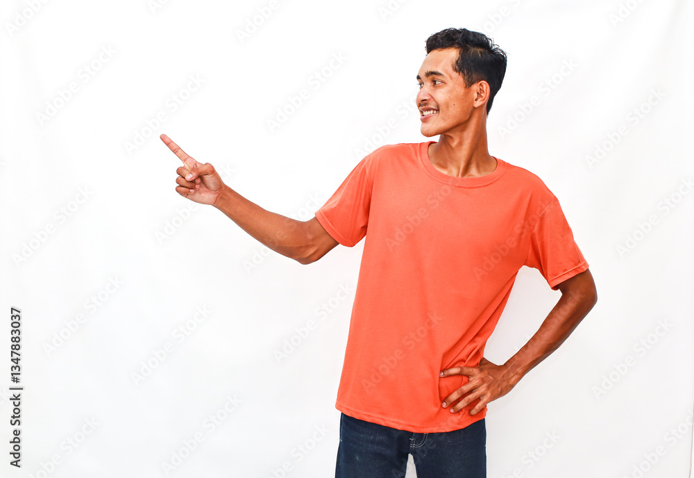 Smiling Young Man Pointing Towards Plain Background