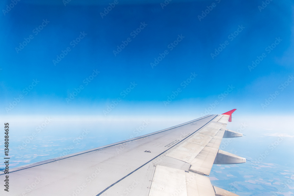 View from the airplane window at a beautiful cloudy sky and the airplane wing View from the airplane window at a beautiful cloudy sky and the airplane wing