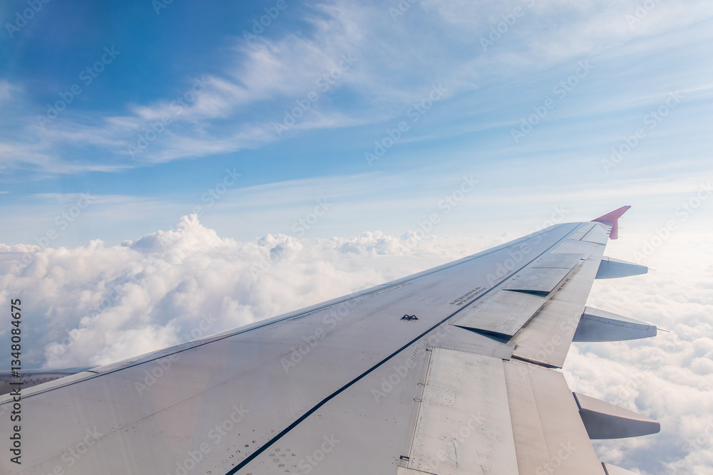 View from the airplane window at a beautiful cloudy sky and the airplane wing View from the airplane window at a beautiful cloudy sky and the airplane wing