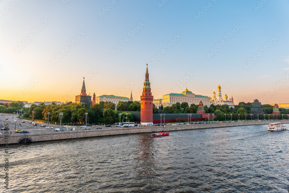 Obraz premium View of Kremlin with Vodovzvodnaya tower, Grand Kremlin Palace from repaired Bolshoy Kamenny Bridge in Moscow city on sunny summer day. Cruise ship sails on the Moscow river