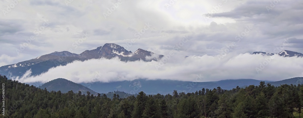 Obraz premium Storm clouds rolling in over the snow-capped mountains in Rocky Mountain National Park. 
