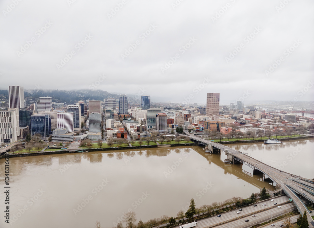 Fototapeta premium A city with a river running through it and a bridge over it