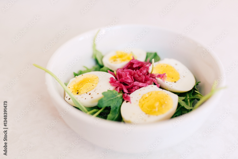 A fresh salad bowl with boiled eggs, arugula, and pickled cabbag A fresh salad bowl with boiled eggs, arugula, and pickled cabbag