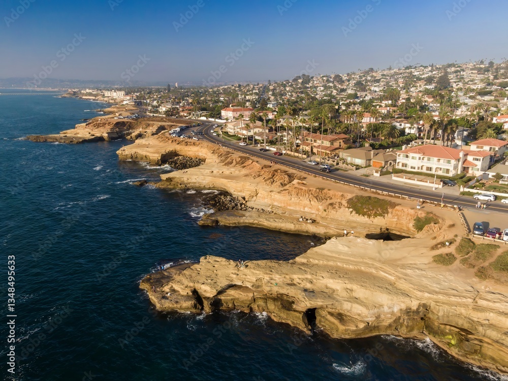 Aerial view of the sandstone cliffs and Pacific Ocean coastline in La Jolla, California, USA. People are enjoying the scenic views and exploring the tide pools. Aerial view of the sandstone cliffs and Pacific Ocean coastline in La Jolla, California, USA. People are enjoying the scenic views and exploring the tide pools.
