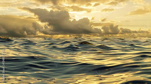 The sky is cloudy and the sun is setting. The water is calm and the sky is orange