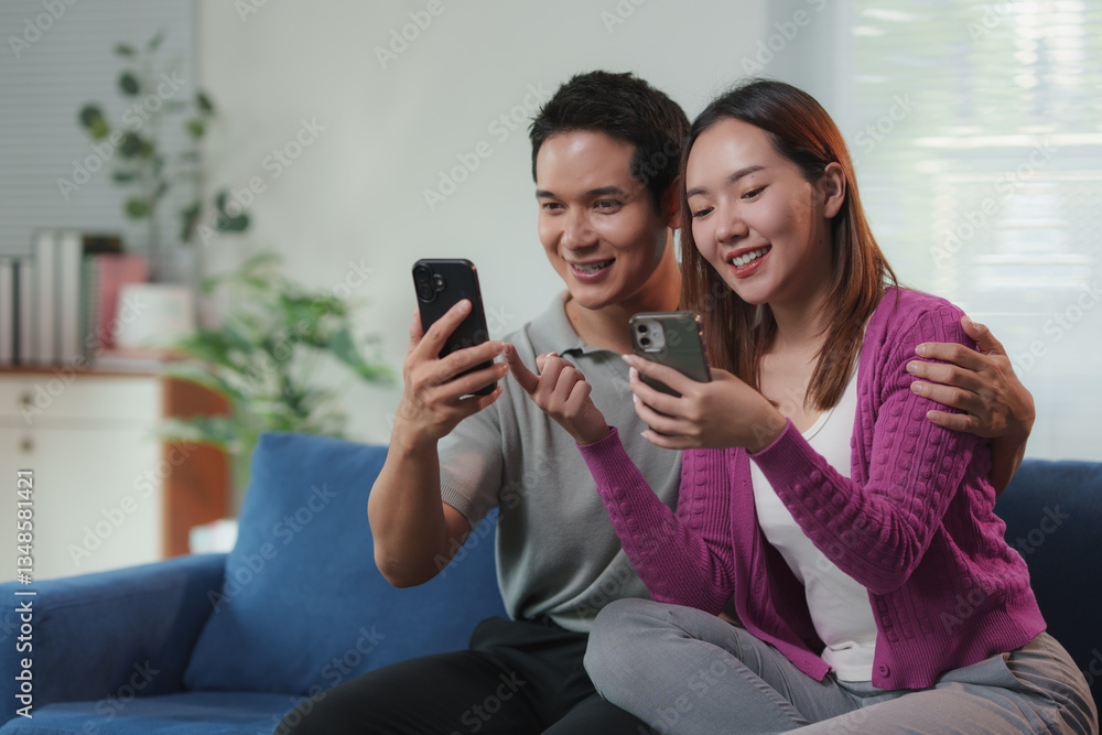 Smiling couple sitting on sofa at home, browsing online store on their smartphones and using credit card, enjoying convenient and secure online shopping experience Smiling couple sitting on sofa at home, browsing online store on their smartphones and using credit card, enjoying convenient and secure online shopping experience