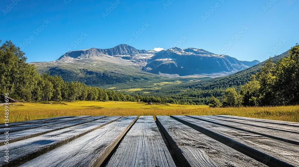 Fototapeta premium Landscape photograph of a majestic mountain range beneath a clear blue sky, with a wooden table in view. -