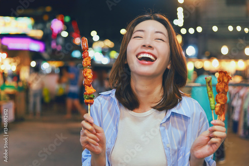 Photography Happy young Asian woman walking in the night market,woman enjoying street food a