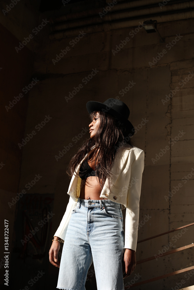 Fototapeta premium Stunning African American woman wearing casual clothing and posing outdoor. Vertical.