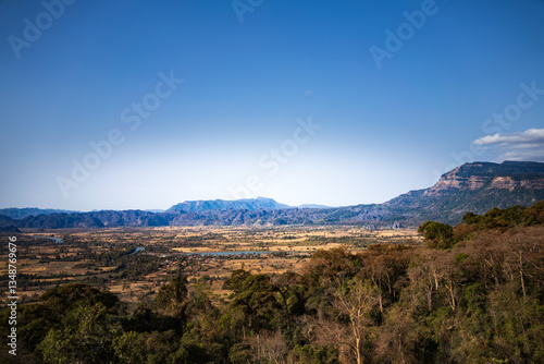 A panoramic view of the landscape in Laos, showcasing the vast valleys, mountains, and forests.
