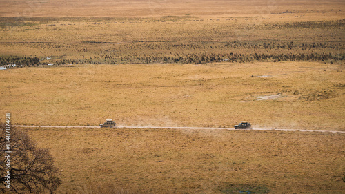 Two jeeps carrying tourists on safari are driving through ngorongoro crater in tanzania, africa