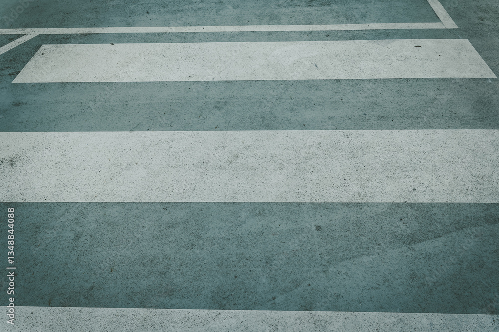 Fototapeta premium Pedestrian crossing lines on pavement in urban area during daylight hours