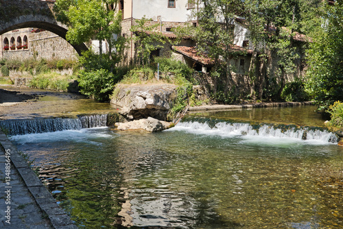 Billede på lærred Waterfalls in the Quiviesa river as it passes through the town of Potes in the peaks of Europe, which is approaching its end, flowing a few meters downstream into the Deva river