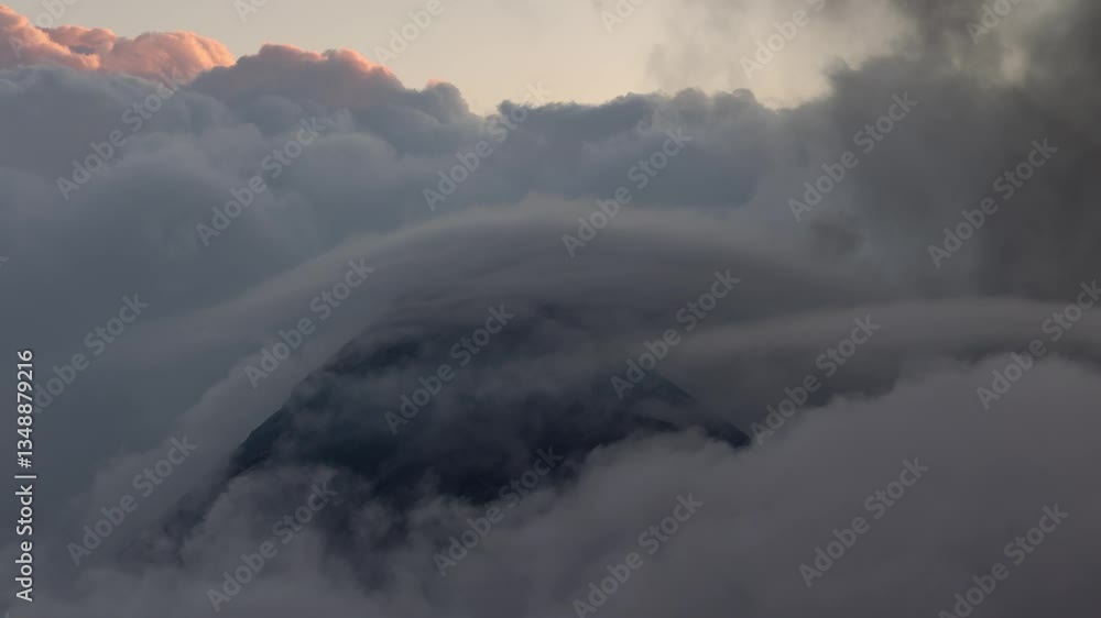 Volcano Fuego cone visible in cloud at dawn, drone view above clouds Volcano Fuego cone visible in cloud at dawn, drone view above clouds