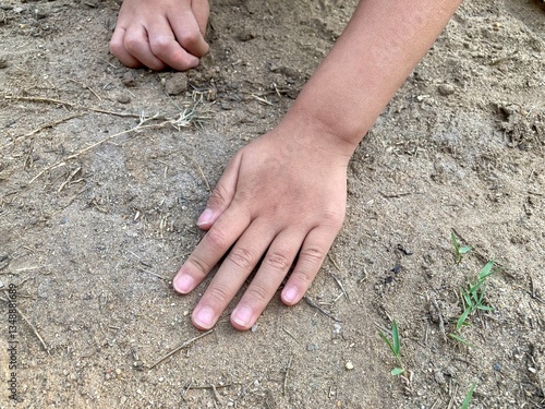 Obraz na płótnie Hands of a preschool boy playing with sand outdoors. Concept of promoting learning, play, child development. w salonie