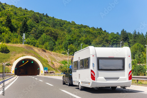 Scenic view big modern white family rv camper van vehicle drive Europe highway road alpine mountain cloud in summer day. Rving motorhome lifestyle travel and adventure tourism trip journey concept
