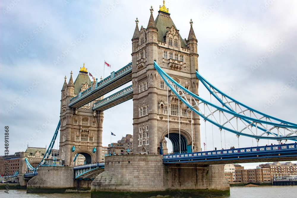 Obraz premium Elaborate architecture of the iconic London Tower Bridge along the Thames River. Photo taken in London United Kingdom during a cloudy day