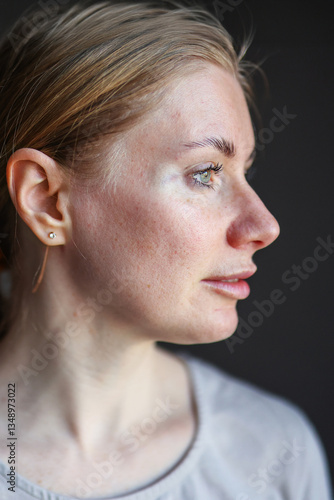 Photos Pensive woman inspecting her complexion in natural light.