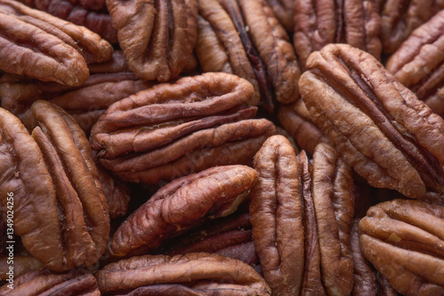 Close up detailed photograph of dried pecan nuts without shell with selective focus. Beautiful pecans background. Healthy eating and snack, whole foods. Natural fats, fibre, minerals, vitamins.