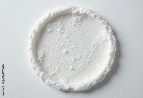 Circular White Cream with Textured Surface on a Plain Background