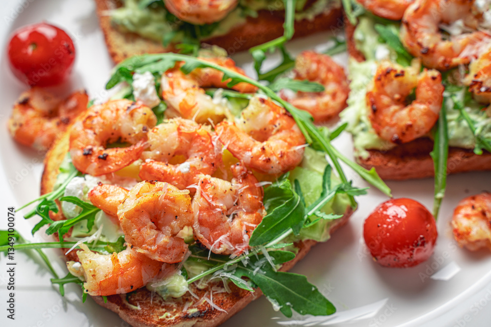 Toast with shrimp, avocado and arugula on a white plate with cherry tomatoes. Close-up. Healthy and Tasty Breakfast Concept Toast with shrimp, avocado and arugula on a white plate with cherry tomatoes. Close-up. Healthy and Tasty Breakfast Concept
