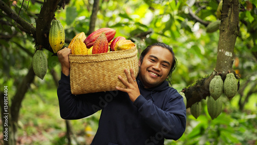 Portrait of a smiling young indonesian cacao farmer looking at the camera on a plantation with harvested pods