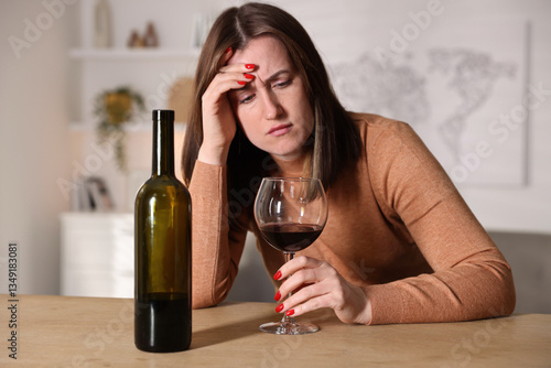 Obraz na płótnie Alcohol addiction. Miserable woman with wine at table indoors w salonie
