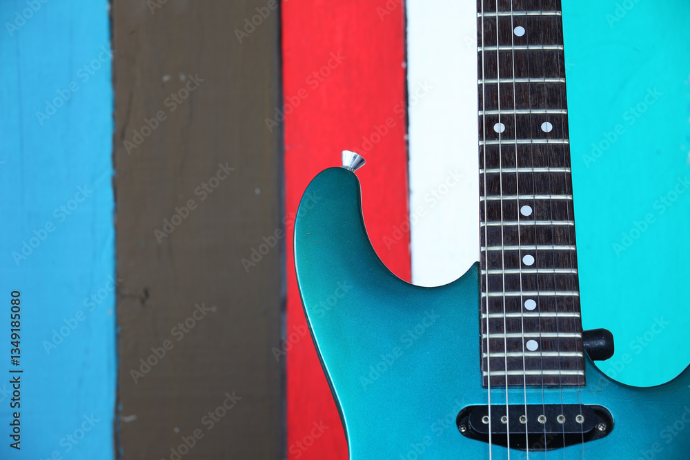 Obraz premium Vibrant Electric Guitar Against Colorful Wooden Background