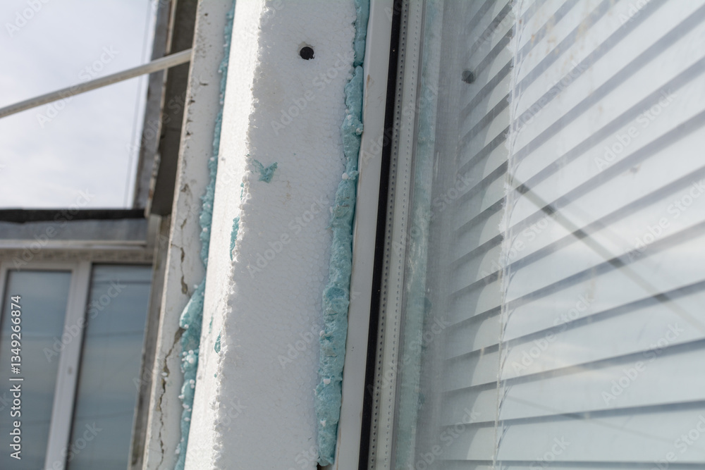 Fototapeta premium Insulation of the facade of a panel house with foam plastic. Window insulation. Selective focus, shallow depth of field