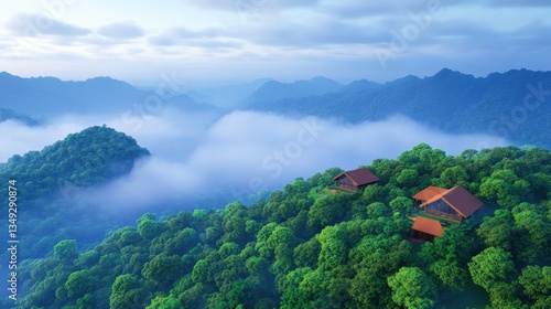 A serene aerial view of lush green mountains with mist, featuring cozy wooden homes nestled among the trees.