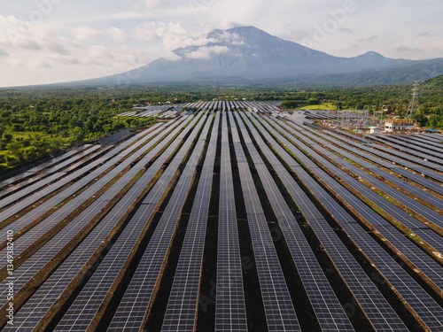 Aerial View of Solar Power Plant with Majestic Volcano in the Background, Indonesia.
