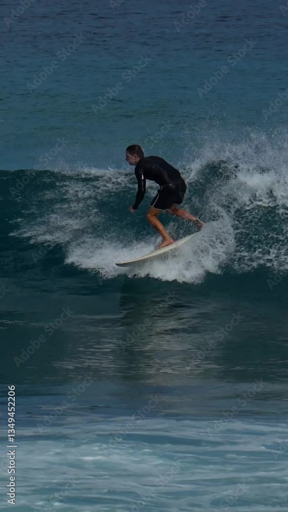 Male surfer ridding a wave under blue sky in a hot sunny day. Vertical slow motion video. Maldives Male surfer ridding a wave under blue sky in a hot sunny day. Vertical slow motion video. Maldives