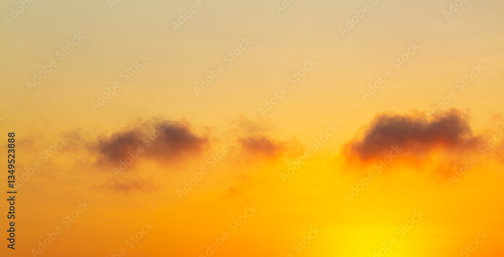 Fototapeta premium Clouds and orange sky,Beautiful Vivid sky painted by the sun leaving bright golden shades,Yellow sunlight in Golden hour or morning sunrise, Horizon sky nature background