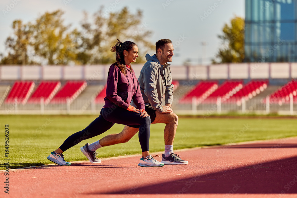 Obraz premium Couple Stretching Together Outdoors on Track in Sunny Weather