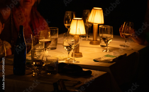 Warm ambiance at a cozy dining table with soft lighting and elegant glassware during an intimate evening gathering with friends and family