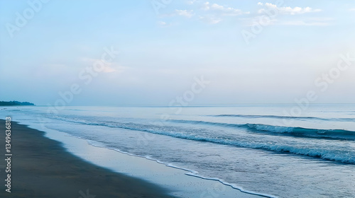 Blue Ocean Waves Rolling Onto Sandy Beach Under Clear Sky During Peaceful Afternoon