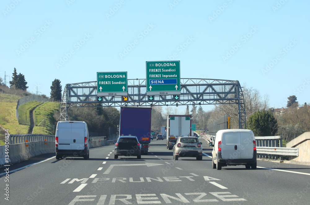Fototapeta premium sign on an italian highway showing italian city names with cars and vans