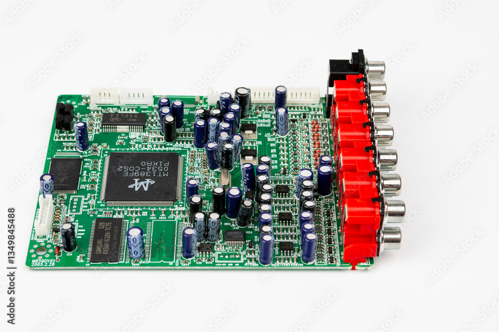 A close-up of the processor microchip surrounded by other electrical components on a green circuit board. Also on the board is a row of several speaker connectors. A close-up of the processor microchip surrounded by other electrical components on a green circuit board. Also on the board is a row of several speaker connectors.