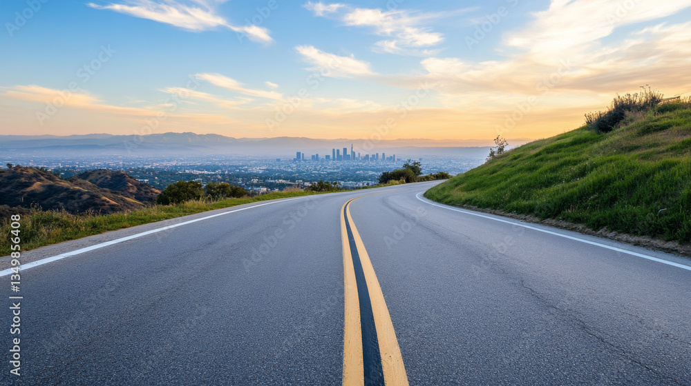 Fototapeta premium A winding road gracefully descends towards the sprawling skyline of Los Angeles, illuminated by the golden hues of sunset. Lush greenery lines the roadside, creating a tranquil atmosphere