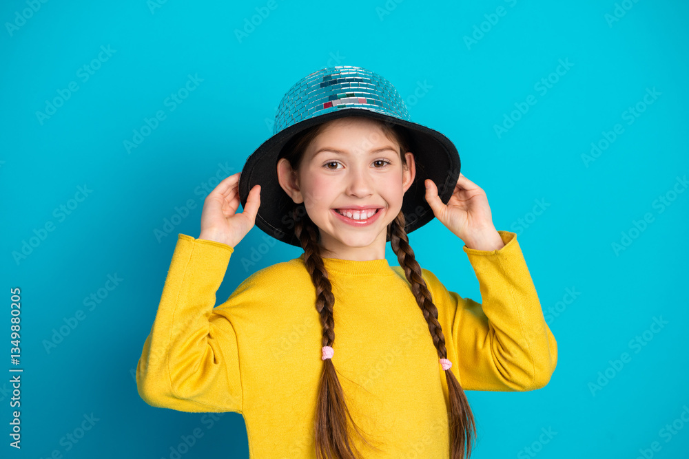 Charming Young Girl With Braided Hair Wearing a Stylish Outfit and Hat Posing Cheerfully Against a Bright Blue Background Charming Young Girl With Braided Hair Wearing a Stylish Outfit and Hat Posing Cheerfully Against a Bright Blue Background
